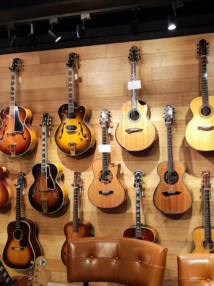 Acoustic and electric guitars on the wall.