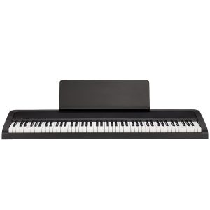 digital piano in black with a full 88-key weighted keyboard, matching stand, and three-pedal unit, shown in a modern home setting